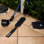 A90 Leg Day Set with ankle straps and hip bands laid out on a tiled floor, ready for an outdoor workout session.